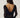 Noella N-Madaline Top Black sett bakfra på modell – sort glitrende mesh-topp med lange ermer og elegant drapert fosseffekt i ryggen.