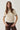 Modell forfra med N-Marthy Knit Ivory Brown fra Noella – lys strikkegenser med brune kontrastdetaljer og brystlomme.