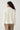 Modell bakfra med N-Maidie Knit Offwhite fra Noella – lys offwhite strikkegenser med lange ermer og avslappet passform.
