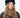 Modell med Jen Harka Hat Black fra Sui Ava – sort hatt i semsket lammeskinn med myk, matt overflate.