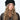 Modell med Jen Harka Hat Black fra Sui Ava – sort hatt i semsket lammeskinn med myk, matt overflate.