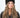 Modell med Jen Harka Hat Brown fra Sui Ava – brun hatt i semsket lammeskinn med myk, matt overflate.