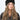 Modell med Jen Harka Hat Brown fra Sui Ava – brun hatt i semsket lammeskinn med myk, matt overflate.