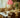 Soft Serve Pendant 03 Peach fra Crème Atelier hengende over et dekket spisebord – skulpturell ferskenfarget lampe med organisk Soft Serve-form.