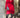 Modell i A-View Carrie Dress Red – kort, rød omslagskjole med glansfull satenglook, V-utringning, lange ermer, knyting i midjen og asymmetrisk skjørt med volanger. Kjolen er stylet med sorte strømpebukser, burgunder pumps og en sølvfarget paljettveske.
