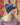 Modell utendørs med MSCH Copenhagen Hope Icon Beanie i melert blå – en myk strikkelue med bred oppbrettet kant og liten hvit logolapp foran. Luen er stylet med en chunky strikkegenser i rosa og burgundertoner.