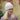 Modell utendørs med MSCH Copenhagen Hope Icon Beanie Oatmeal – myk, lys beige melert strikkelue med ribbestrikk, bred oppbrettet kant og hvit logolapp foran. Luen er stylet med en rosa og burgunder melert strikkegenser.