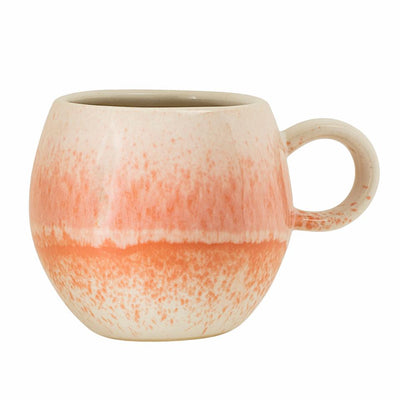keramikkrus i hvit farge som synker inn til en oransjfarge mot midten av kruset